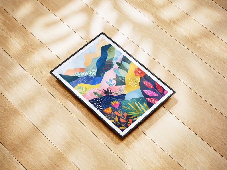 May include: A rectangular framed art print with an abstract landscape design. The artwork features a vibrant mix of colours, including blue, pink, and yellow. The black frame contrasts with the colourful print, displayed on a wooden surface.