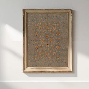 May include: A framed print of a vintage rug with a floral pattern in shades of blue, yellow, and red. The rug is surrounded by a simple wooden frame.