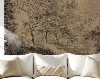 May include: A woven throw blanket featuring a sepia-toned landscape illustration of trees and foliage. The blanket has a dark fringed edge on the left side and displays a detailed, textured pattern of a forest scene in shades of brown.