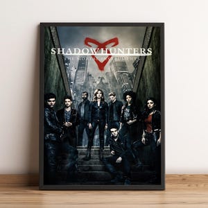 May include: A poster for the TV show "Shadowhunters: The Mortal Instruments". The poster features a group of young adults standing on a set of stairs in front of a city skyline. The show's title is displayed at the top of the poster, along with the show's logo, a red rune.