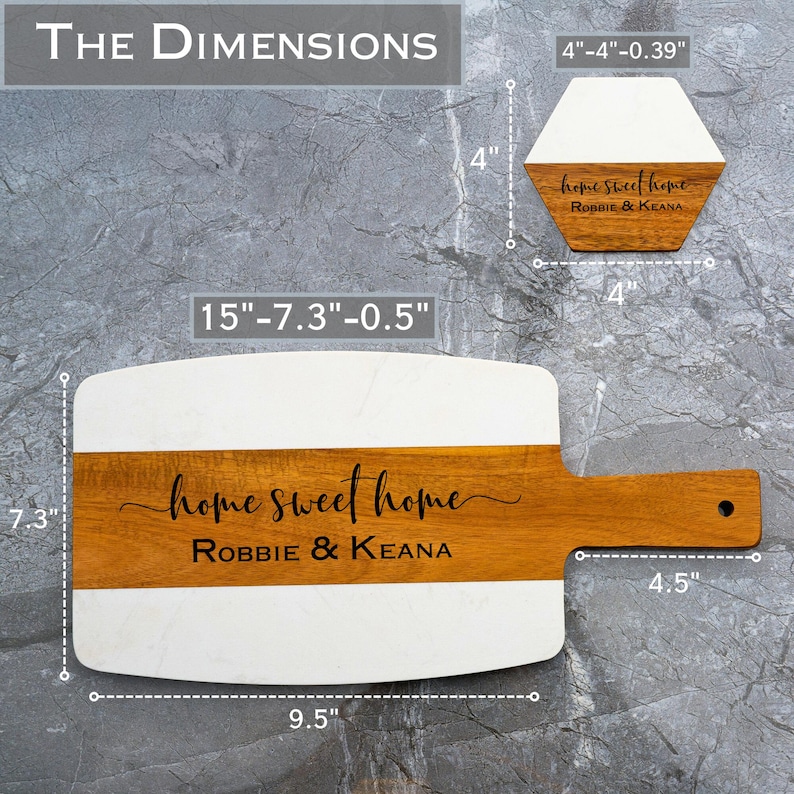 May include: A white and brown rectangular serving board with a wooden handle. The board is 15 inches long, 7.3 inches wide, and 0.5 inches thick. The board has a white marble top and a brown wooden bottom. The board is engraved with the text "home sweet home Robbie & Keana".