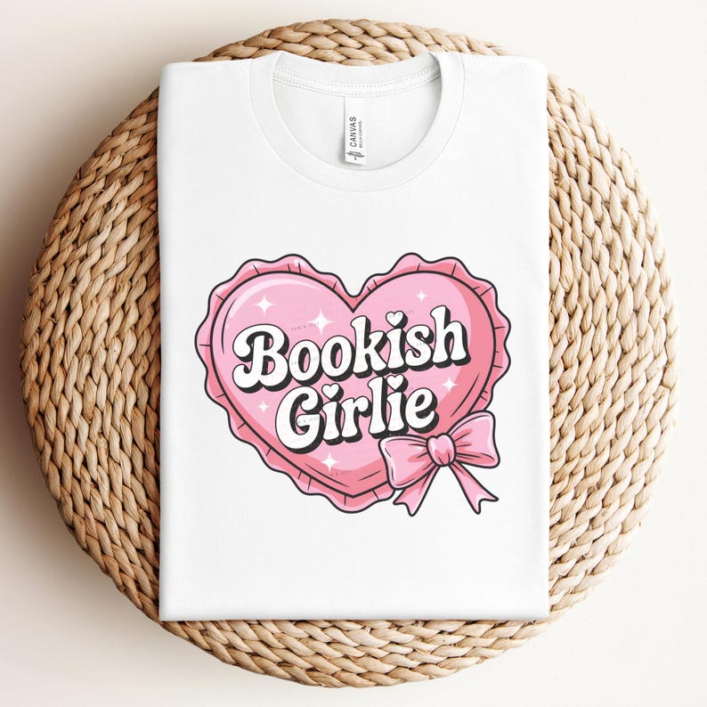 Op de afbeelding: Wit T-shirt met een roze hartgrafiek waarop "Bookish Girlie" in een retro-lettertype staat.