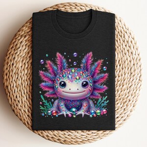 May include: A black t-shirt with a colorful cartoon axolotl wearing a crown of jewels. The axolotl is surrounded by bubbles and seaweed.