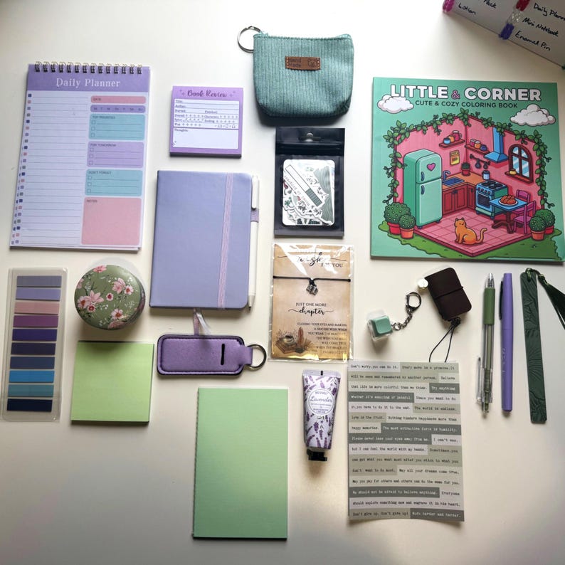 May include: An assortment of stationery items in pastel colours, including a daily planner, notebooks, stickers, and a coloring book. The items feature floral and minimalist designs. A teal pouch, lavender hand cream, and pens are also visible. Measurements are in centimetres.