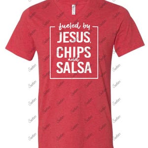 May include: Red V-neck t-shirt with white text that reads "fueled by JESUS, CHIPS and SALSA".