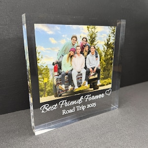 May include: A clear acrylic photo block featuring a group of friends posing in front of a truck. The block has the text "Best Friends Forever Road Trip 2025" in white script. The photo shows a group of people.