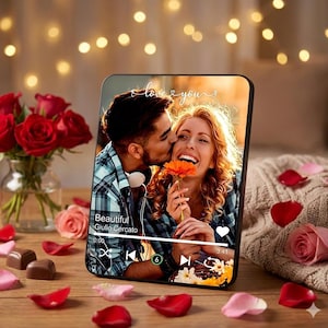 Może przedstawiać: Spersonalizowana ramka na zdjęcia przedstawia całującą się parę z napisem "love & you" powyżej. Ramka otoczona jest czerwonymi różami, płatkami róż i czekoladkami, tworząc romantyczną atmosferę. Ramka wyświetla również interfejs odtwarzacza muzyki.