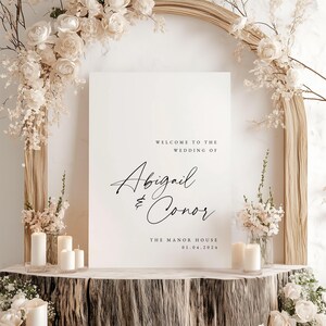 May include: White wedding welcome sign with black calligraphy text that reads "Welcome to the wedding of Abigail & Conor The Manor House 01.04.2024".