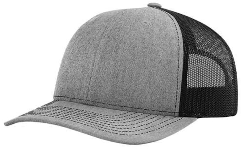 May include: A gray and black trucker hat with a mesh back. The hat has a curved brim and a structured crown.