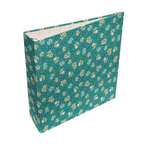 May include: A teal binder with a floral pattern. The binder is covered in a fabric with small yellow, white, and blue flowers. The interior is a cream color with small white dots. The binder is a standard size.