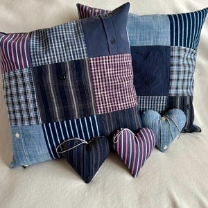 May include: Three patchwork cushions made from repurposed denim and plaid fabric. Two are square and one is heart-shaped. The cushions are all in shades of blue, black, and white.