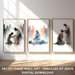 Op de afbeelding: Set van drie ingelijste aquarelprints. Elke print toont een bijbelse scène met figuren in gewaden. Het kunstwerk gebruikt zachte blauwe, bruine en perziktinten, met een focus op licht en schaduw. De tekst onderaan luidt "SET OF THREE WALL ART - MIRACLES OF JESUS DIGITAL DOWNLOAD."