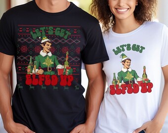 May include: Two t-shirts with a Christmas-themed design featuring a cartoon elf holding a beer and a glass of red liquid. The text on the shirts reads "Let's Get Elfed Up".