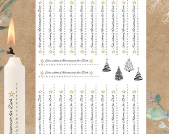Könnte beinhalten: Eine weiße Kerze und ein A4-Bogen Transferfolie mit dem deutschen Text Eine schöne Adventszeit für Dich, nummerierten Listen von 1 bis 24, goldenen Sternsymbolen und schwarzen grafischen Illustrationen von Weihnachtsbäumen auf braunem Grund.