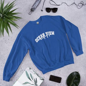 May include: A royal blue sweatshirt with white text that reads "Ocean View 8477".