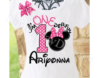 May include: White t-shirt with a pink and white polka dot number one, a black and white Minnie Mouse head with a pink bow, and the text "I'm One Derful" in black. The name "Ariponna" is written in black below the number one.