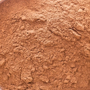 Può includere: Primo piano di un mucchio di polvere di cacao marrone.