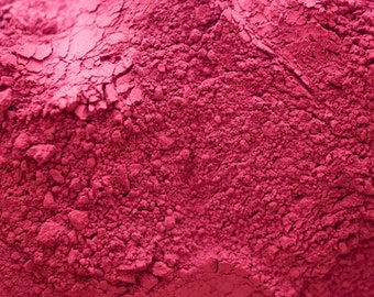 May include: Close-up of a pile of deep pink powder. The powder has a fine, grainy texture.