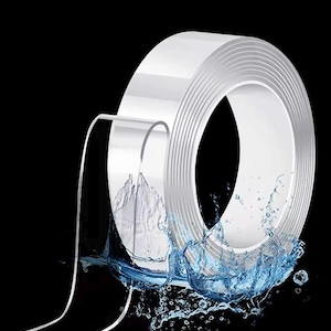 Könnte beinhalten: Eine Rolle durchsichtiges, doppelseitiges Klebeband mit einem Bandstreifen, der sich von der Rolle erstreckt. Das Band ist in Wasser getaucht, was seine wasserdichten Eigenschaften zeigt.