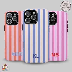 May include: Three phone cases with vertical striped patterns in coral, blue, and pink. Each case has a different initial monogram. The top right corner has a text bubble that says "MORE COLOR OPTIONS!"