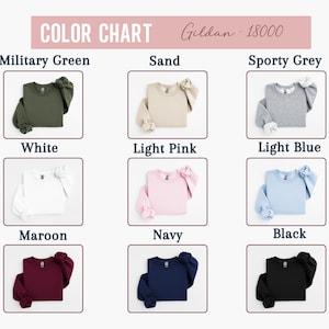 May include: A colour chart displaying Gildan 18000 sweatshirts in a range of colours: military green, sand, sporty grey, white, light pink, light blue, maroon, navy, and black. Each sweatshirt is folded.