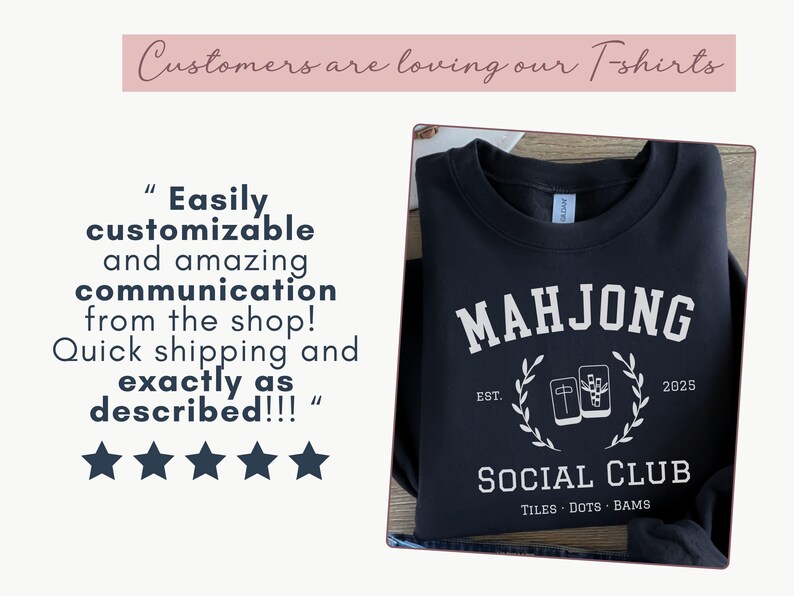 May include: Black sweatshirt with white text reading "MAHJONG SOCIAL CLUB" with a graphic of mahjong tiles. The text "EST. 2025" is also included. The sweatshirt is folded on a wooden surface.