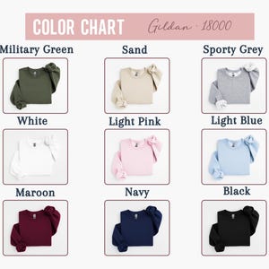 May include: Color chart of Gildan 18000 sweatshirts in various colors, including military green, sand, sporty grey, white, light pink, light blue, maroon, navy, and black. Each sweatshirt is neatly folded.
