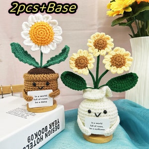 以下が含まれることがあります： 白いデイジーと黄色いひまわり、2つの花のアレンジメント。どちらもかわいい顔をしていて、「バラがいっぱいの世界で、デイジーになろう」と「バラがいっぱいの世界で、ひまわりになろう」と書かれた看板を持っています。