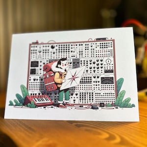 May include: Illustration of a person with a backpack holding a map in front of a large electronic music synthesizer. A red keyboard and green foliage are at the base of the synthesizer. The person is wearing a yellow jacket and green pants.