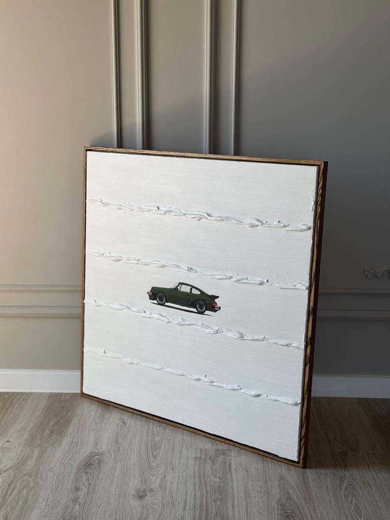 K&ouml;nnte beinhalten: Ein wei&szlig;es Leinwandbild mit einem gr&uuml;nen Auto in der Mitte. Die Leinwand ist mit wei&szlig;er Farbe texturiert und hat einen Holzrahmen.