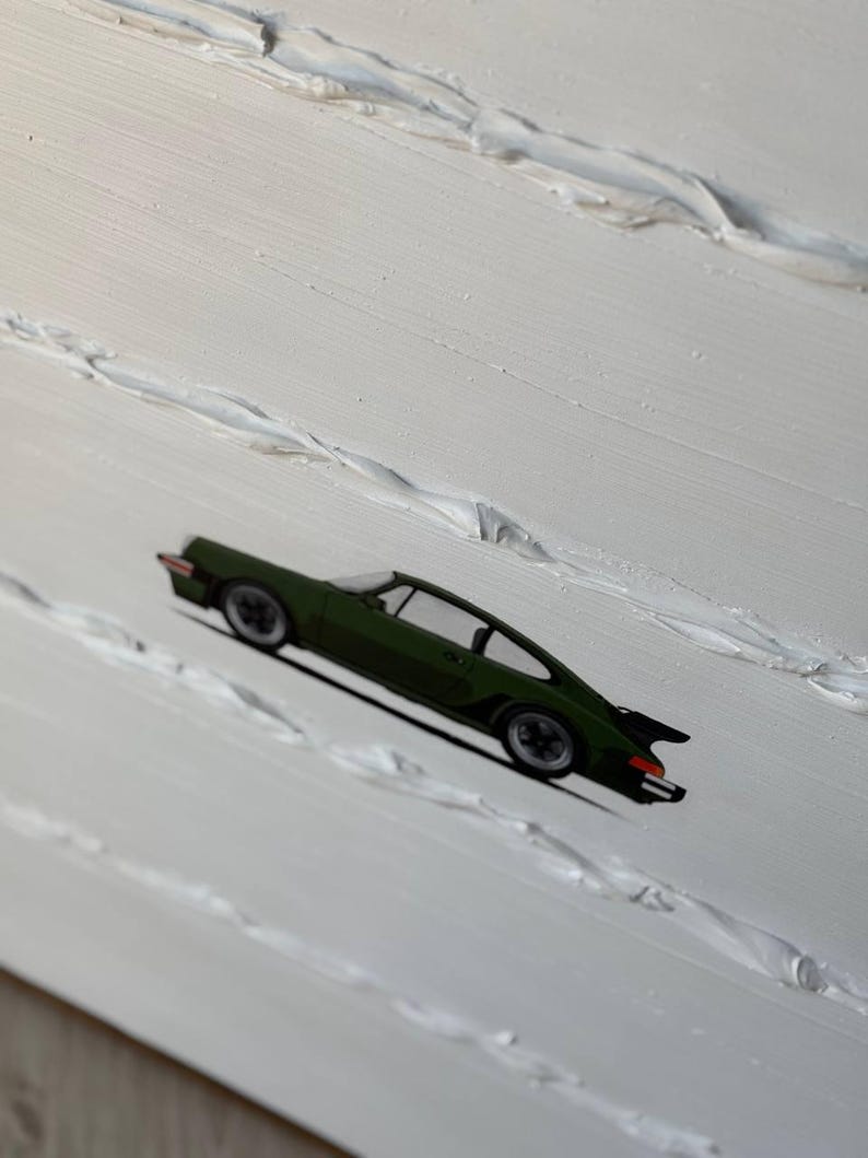 K&ouml;nnte beinhalten: Ein gr&uuml;nes Auto, das auf einem wei&szlig;en, strukturierten Hintergrund gemalt ist.