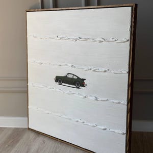 K&ouml;nnte beinhalten: Ein wei&szlig;es Leinwandbild mit einem gr&uuml;nen Auto in der Mitte. Die Leinwand ist in einem dunklen Holzrahmen gerahmt. Das Bild hat eine strukturierte Oberfl&auml;che.
