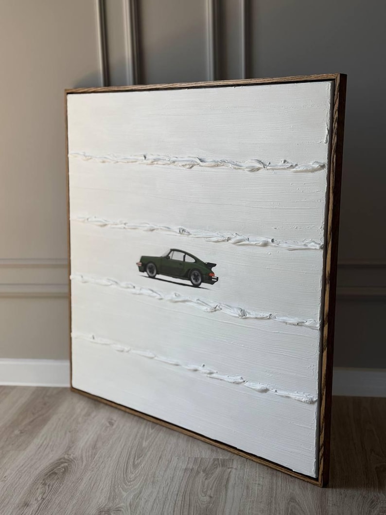 K&ouml;nnte beinhalten: Ein wei&szlig;es Leinwandbild mit einem gr&uuml;nen Auto in der Mitte. Die Leinwand ist in einem dunklen Holzrahmen gerahmt. Das Bild hat eine strukturierte Oberfl&auml;che.