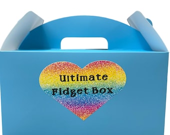 May include: A blue cardboard box with a handle. The box has a rainbow heart sticker with the text "Ultimate Fidget Box" on it.