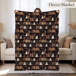 May include: A fleece blanket featuring a repeating pattern of bookshelves filled with various books, small potted plants, and white ghost figures against a black background. The text Fleece Blanket is printed in the upper right corner.