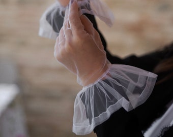Eleganza eterea: guanti da sposa bianchi trasparenti con delicata volant