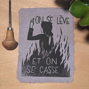 Könnte beinhalten: Schwarz-weiß-Druck auf strukturiertem Papier mit dem Text "On se lève et on se casse". Der Druck zeigt eine Silhouette einer Person, die in Flammen steht.