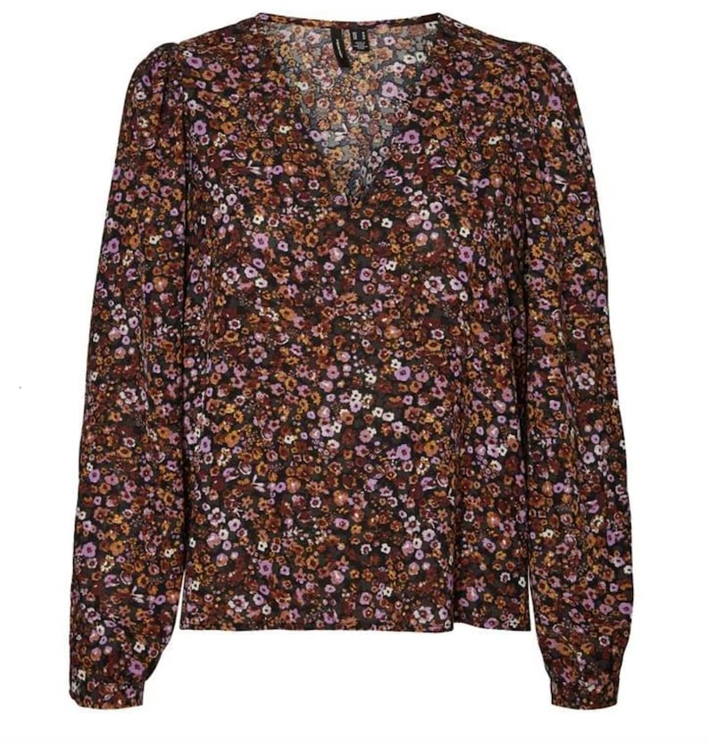 May include: A long-sleeved, V-neck blouse with a brown and black floral print. The blouse has a relaxed fit and a slightly gathered neckline.