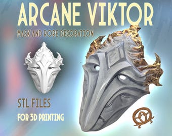 May include: A white 3D printed mask with gold accents. The mask is a stylized representation of a face with sharp angles and a pointed nose. The text "ARCANE VIKTOR MASK AND ROBE DECORATION" is at the top of the image. The text "STL FILES FOR 3D PRINTING" is at the bottom of the image.