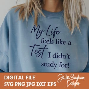 以下が含まれることがあります： My Life feels like a Test I didn't study for! と書かれたダークブルーの文字が特徴のライトブルーのクルーネックトレーナー。長袖でリブ編みのネックラインが施されており、シンプルで清潔感のあるカジュアルな外観を提供しています。