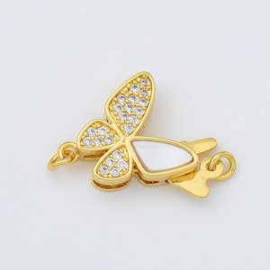 May include: Gold-tone butterfly clasp with clear crystal accents and a white mother-of-pearl centre.