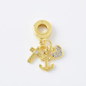 Puede incluir: Encanto dorado con una cruz, un ancla y un corazón con cristales transparentes. El encanto tiene un bucle en la parte superior para sujetarlo a una pulsera o collar.