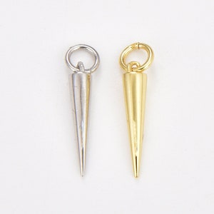 May include: Two metal cone-shaped charms with a loop at the top. The charm on the left is silver and the charm on the right is gold.