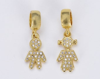 May include: Two gold charm pendants in the shape of a boy and girl. Both charms are covered in small, clear rhinestones.