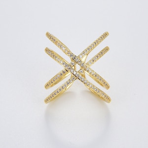 May include: A gold ring with a criss-cross design, accented with small clear stones.
