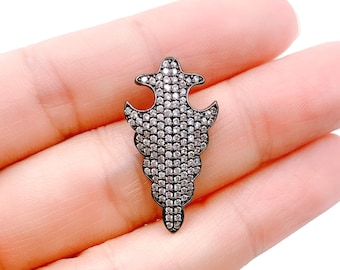 May include: A silver pendant with a black finish and a geometric design. The pendant is covered in small, clear rhinestones.