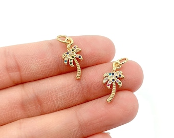 May include: Two gold palm tree charms with colorful crystal accents. The charms are small and delicate, perfect for adding a touch of tropical flair to jewelry.