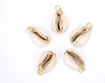 May include: Five gold-rimmed white seashells with a hole at the top for hanging. The seashells are arranged in a star shape on a white background.