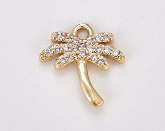 May include: Gold palm tree charm with clear crystal accents. The charm has a loop at the top for attaching to jewelry.