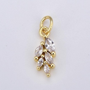 May include: Gold charm with a cluster of clear marquise-shaped crystals. The charm has a loop at the top for attaching to a necklace or bracelet.